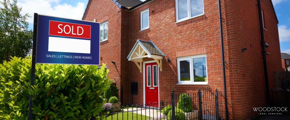 A modern red-brick semi-detached house with a bright red front door and small front garden