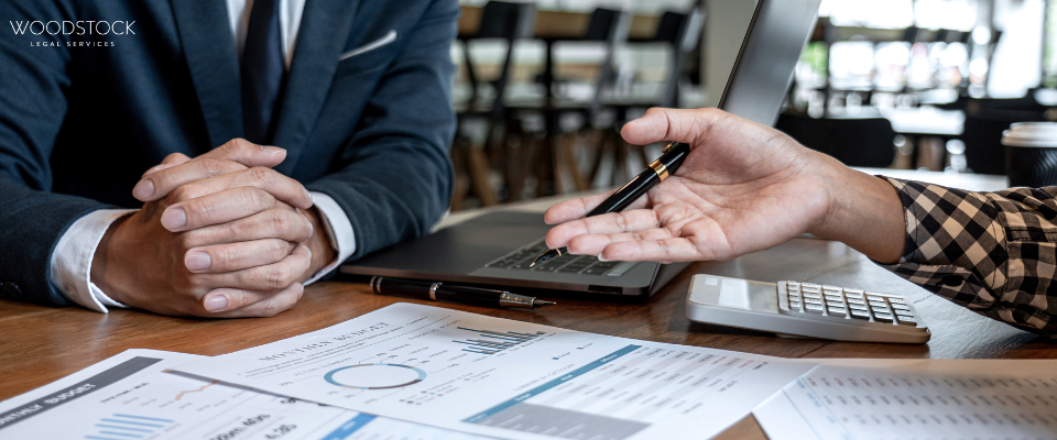 Cardboard moving boxes scattered around a carpeted room, some open with packing paper and bubble wrap visible, suggesting a home move or packing process.