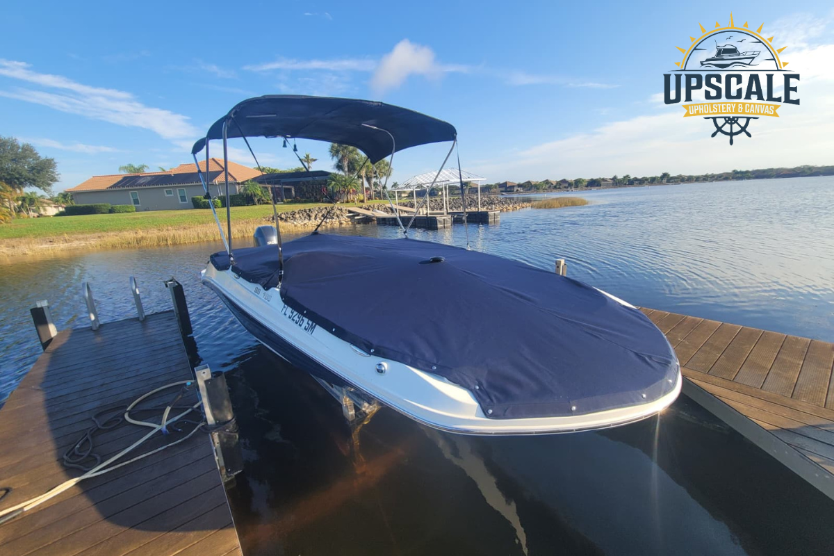 Custom fitted navy boat cover & bimini top installed on white bowrider docked in Florida waterfront.