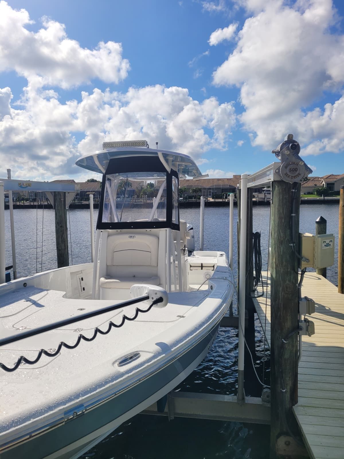 A clean white center console boat docked in Naples, FL, featuring custom marine-grade seating.