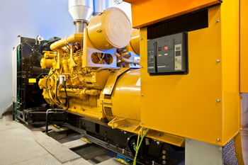 A large yellow generator is sitting in a room.