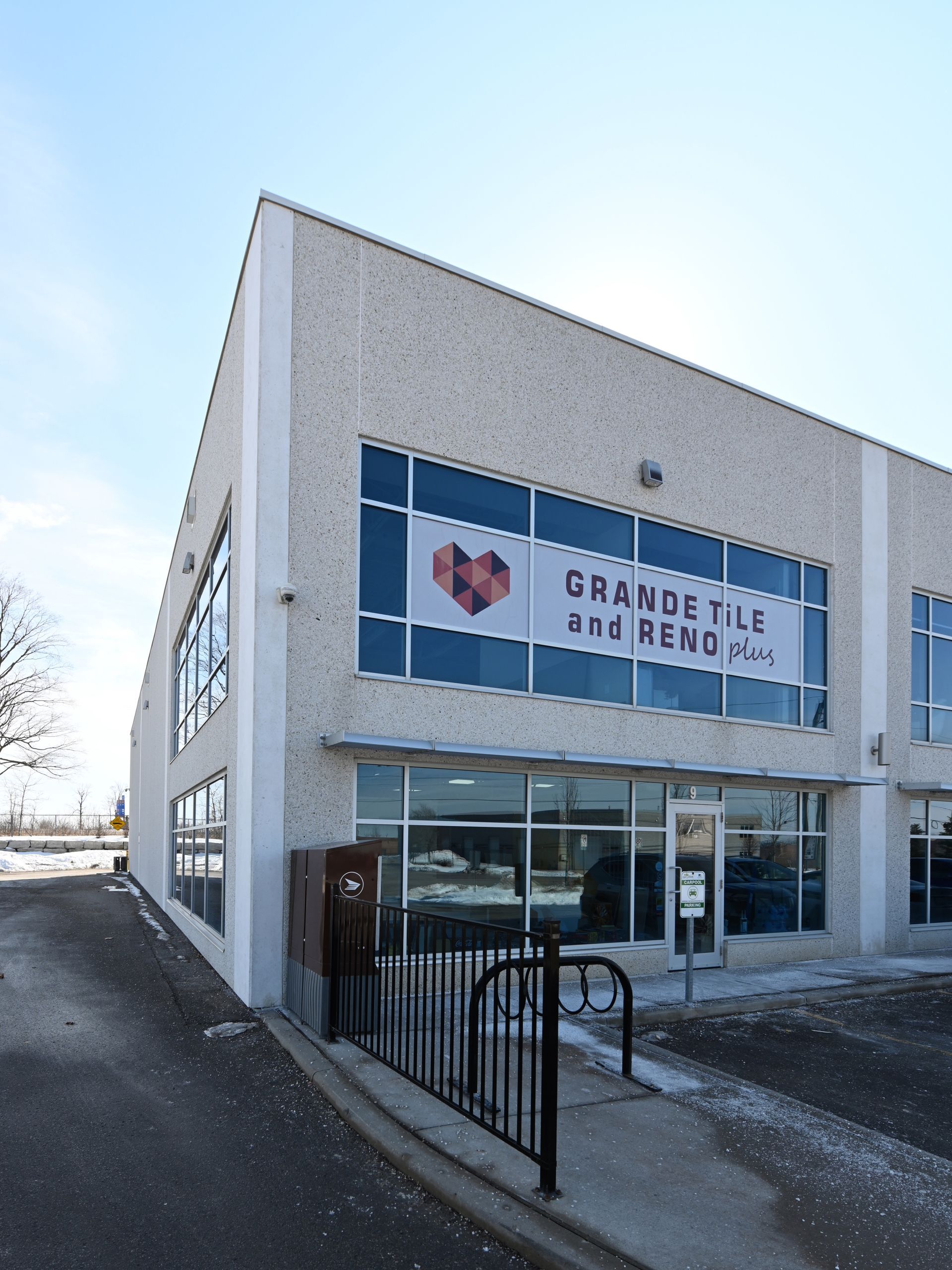 A large building with a sign that says grande tile and remodel