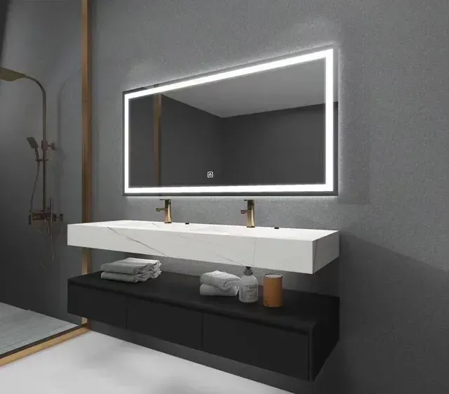 Modern bathroom with floating vanity, backlit mirror, gold fixtures, and gray walls.