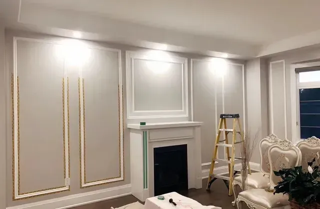 Interior with decorative wall molding, fireplace, ornate chairs, and a ladder.