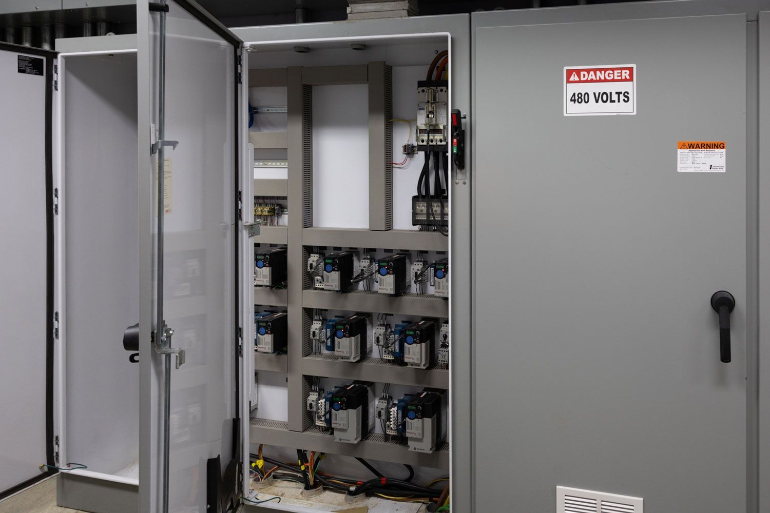 A gray cabinet with a danger sign on it