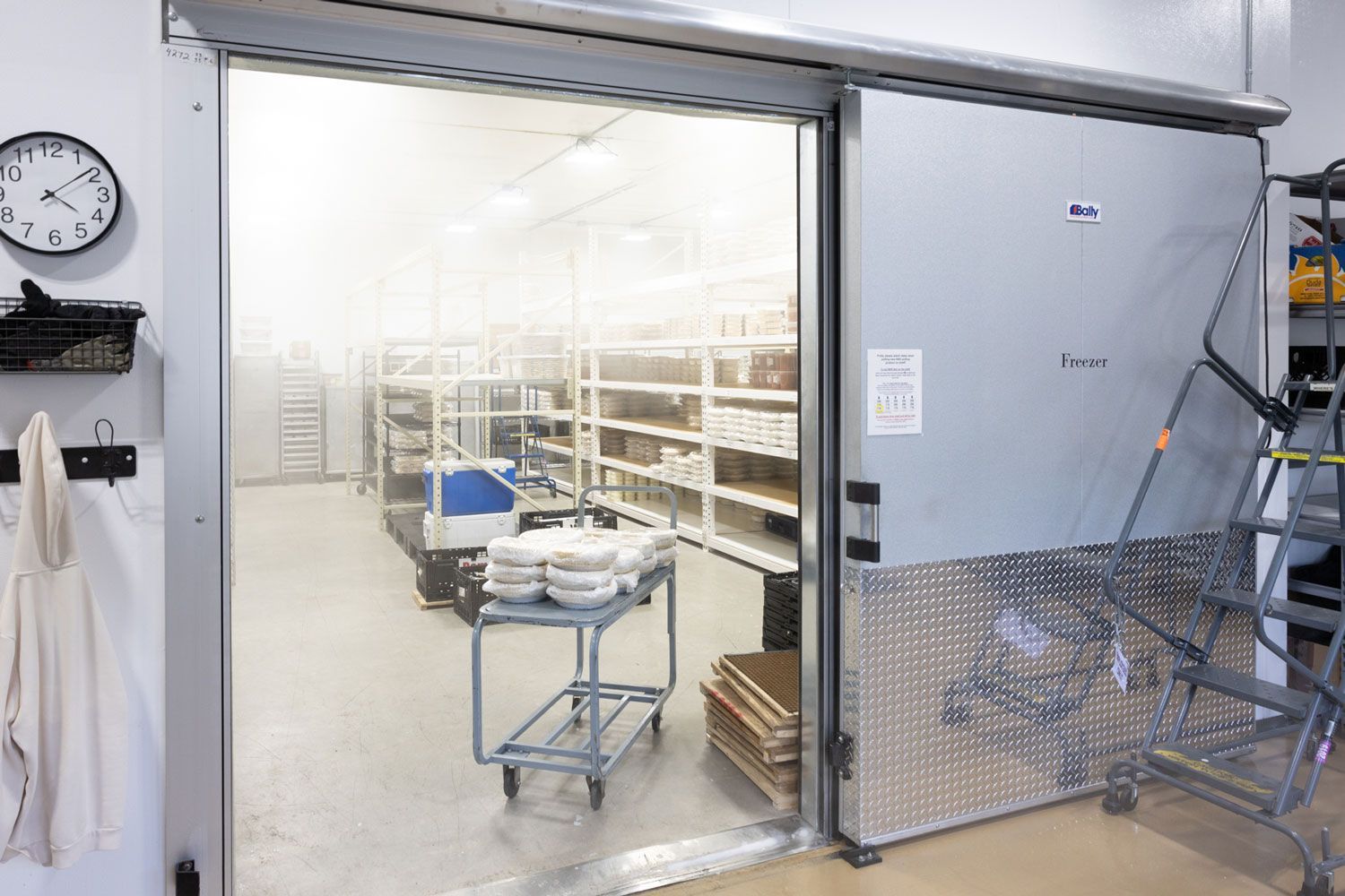 A warehouse with a sliding door and a clock on the wall.