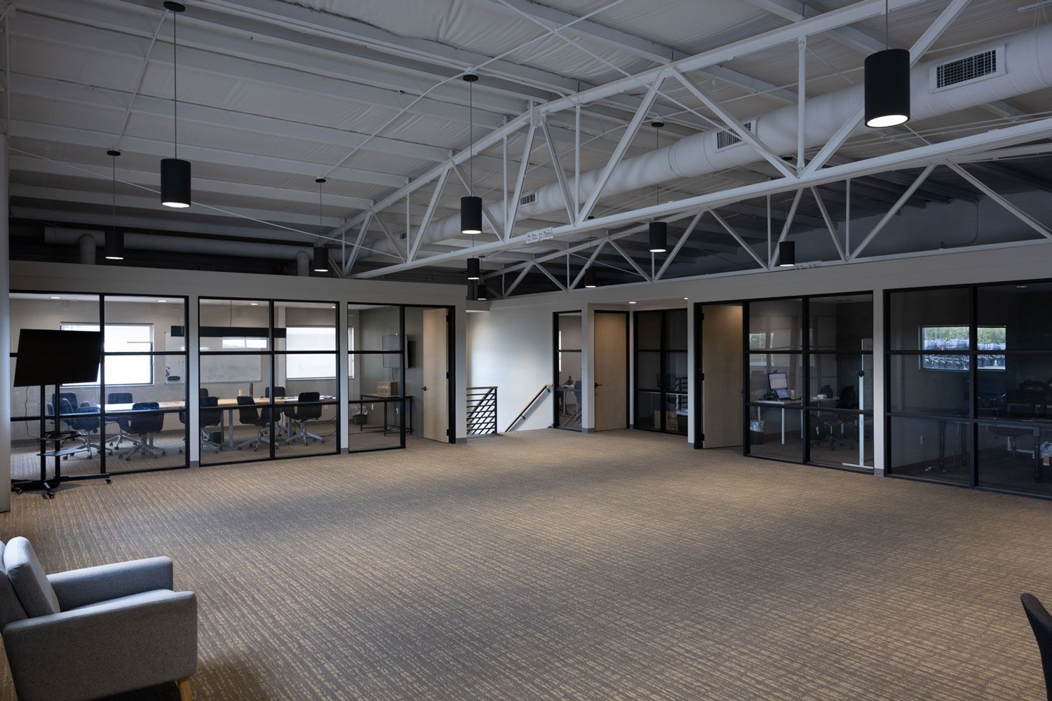 A large room with a lot of windows and a chair