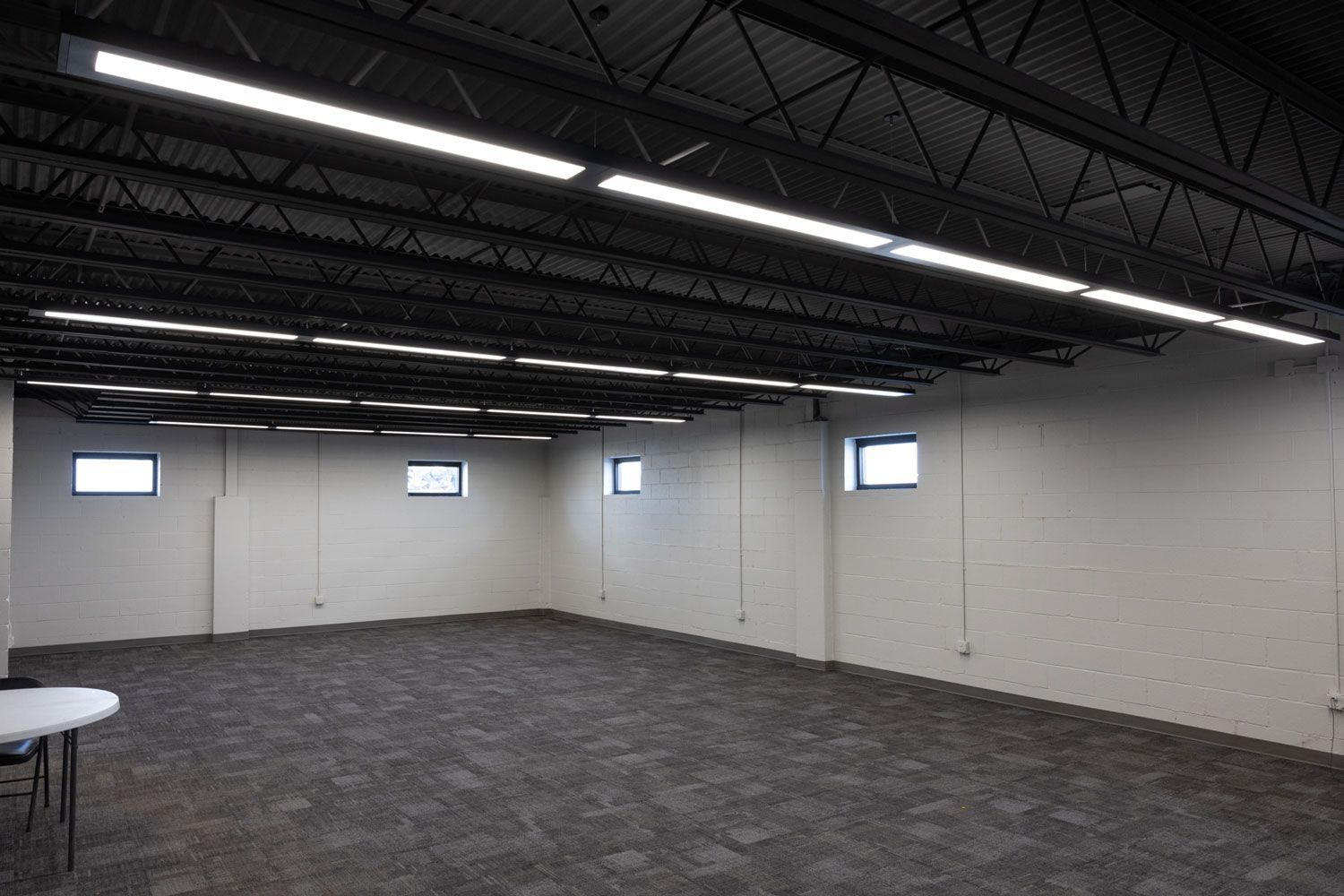 A large empty room with a table and chairs in it.