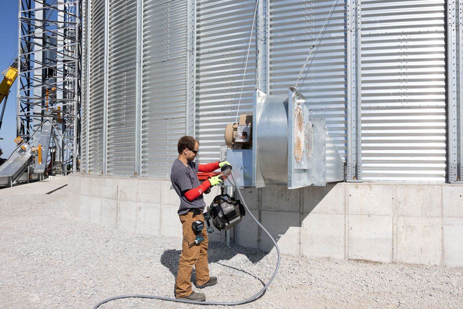 A man is working on a machine outside of a building.
