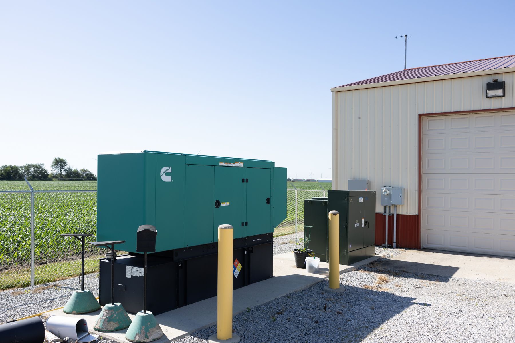 A green box with the word cummins on it sits in front of a building