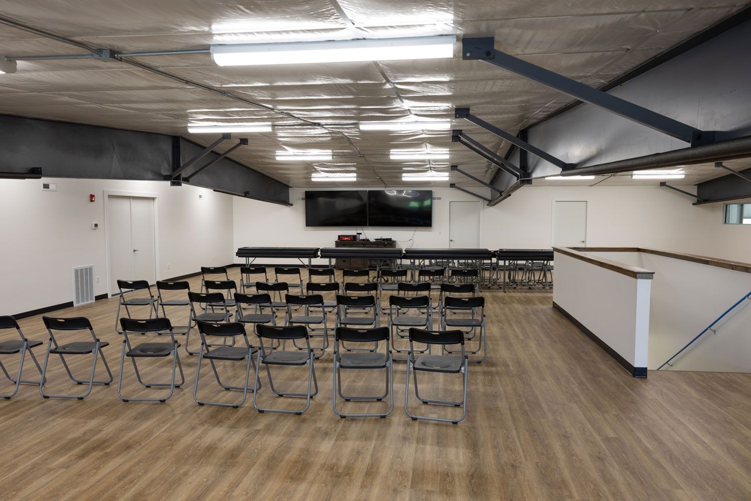 A large room with rows of folding chairs and tables