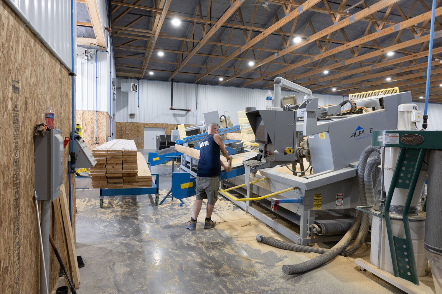A man is standing in front of a machine in a factory.
