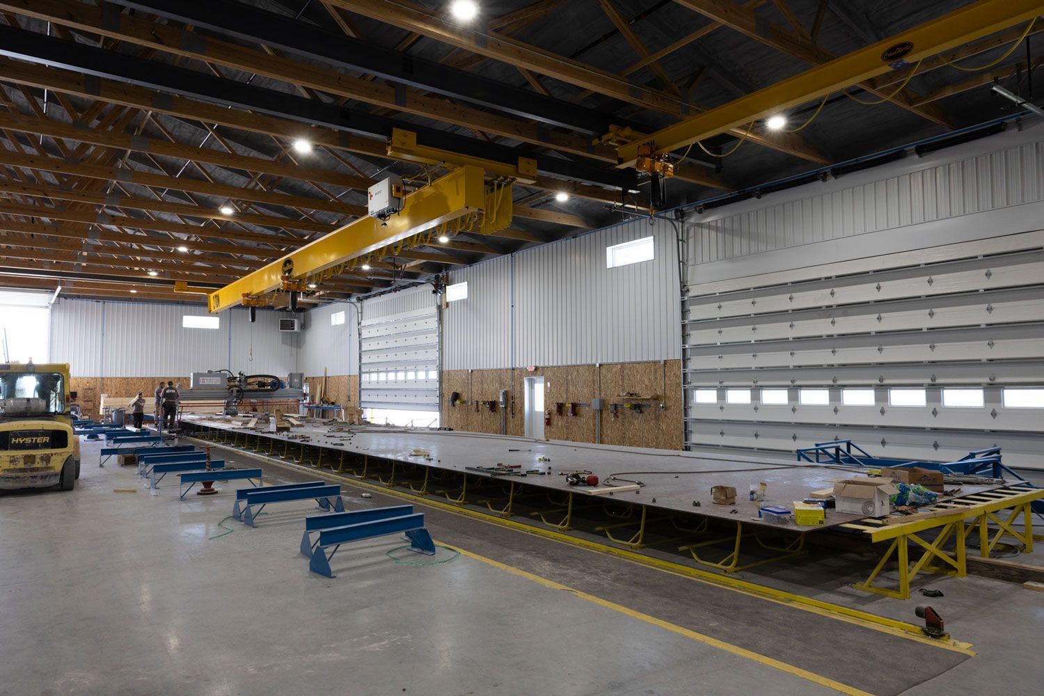 A large warehouse with a yellow crane on top of it