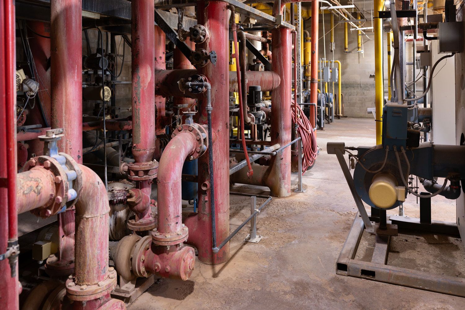 A row of red pipes are lined up in a factory