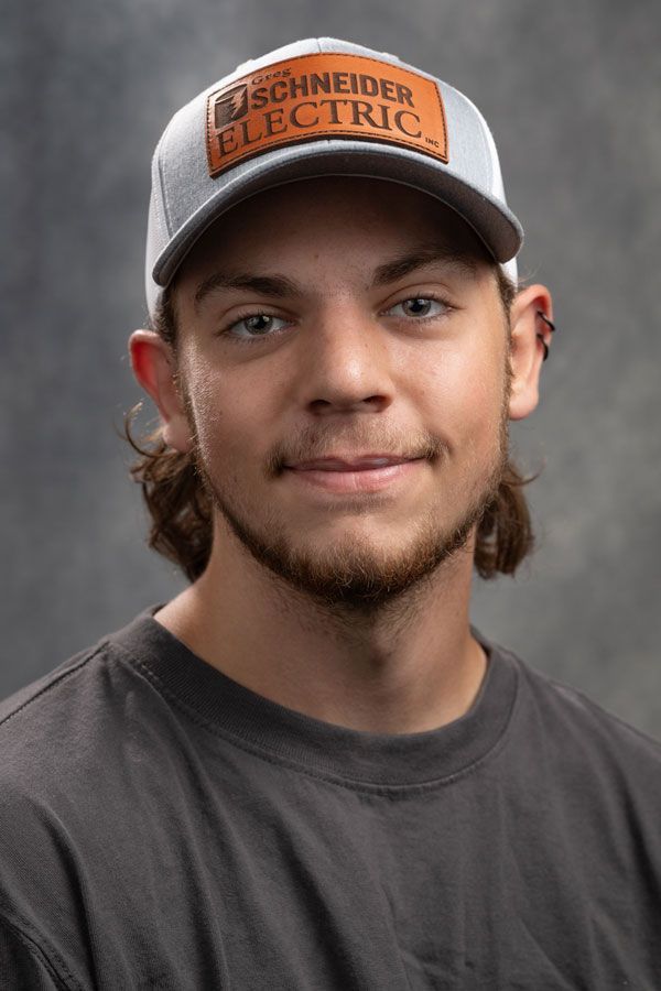A man wearing a hat and a t-shirt is smiling for the camera.