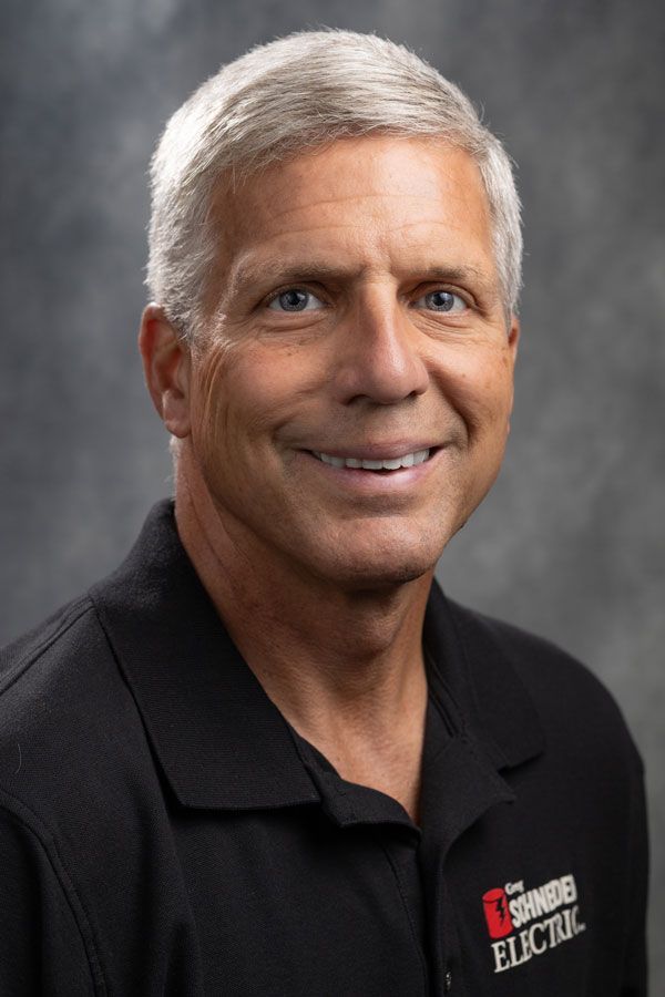 A man in a black shirt is smiling for the camera.