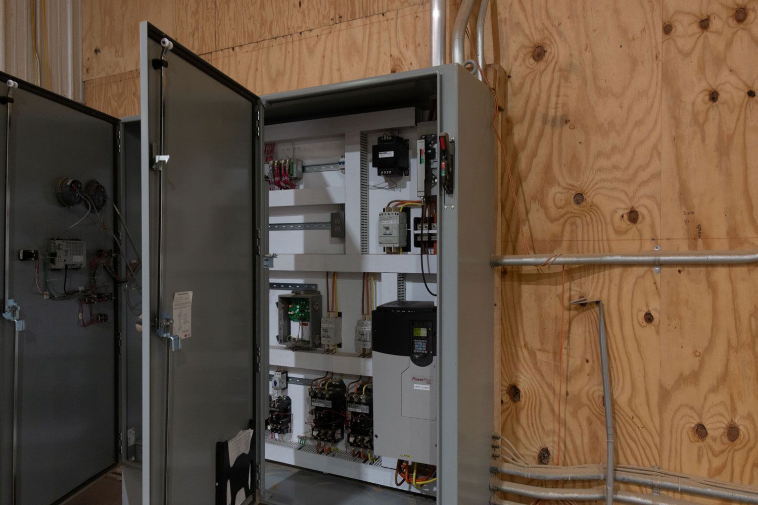 A large electrical box is sitting on a wooden wall.