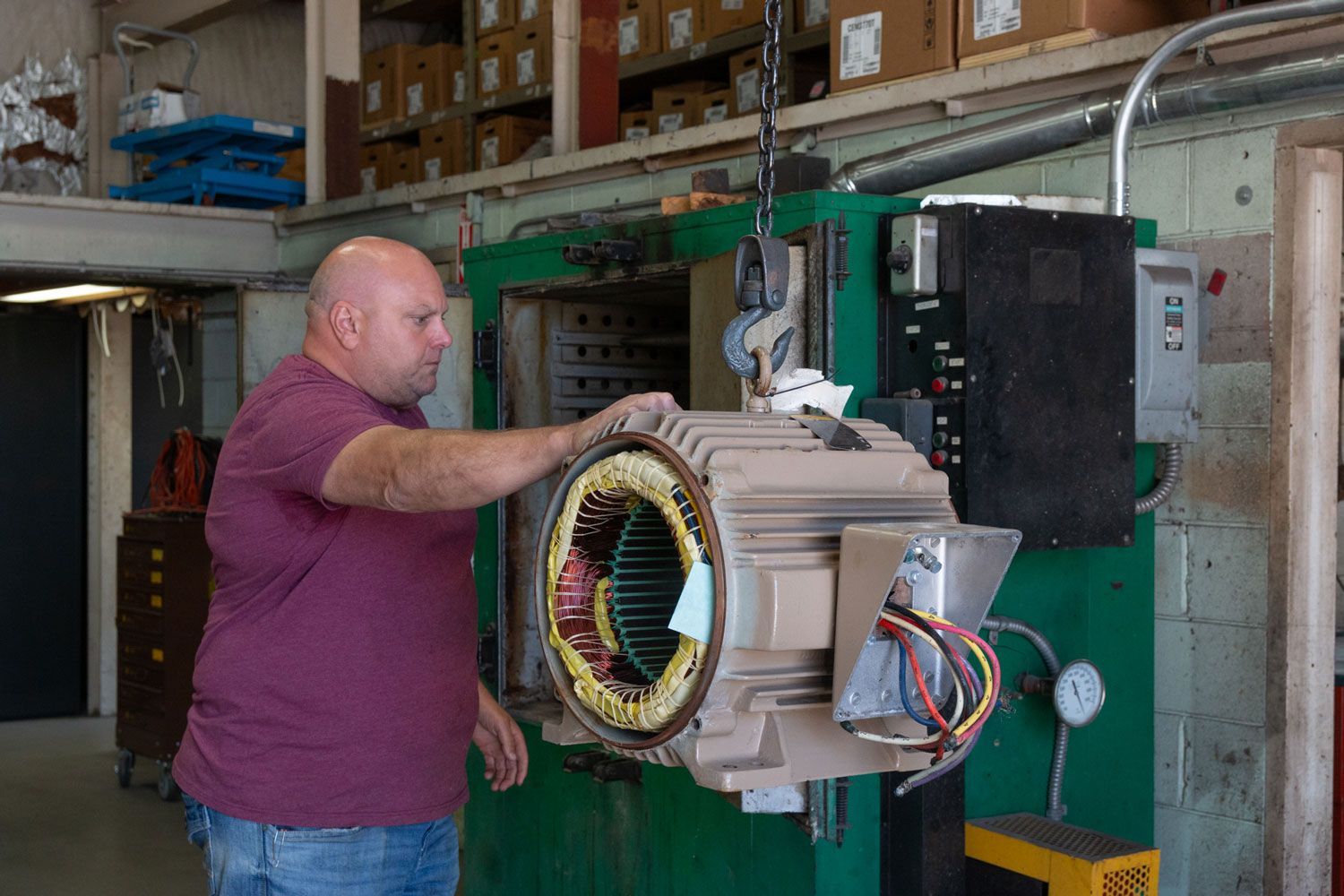 A man is working on an electric motor in a factory.