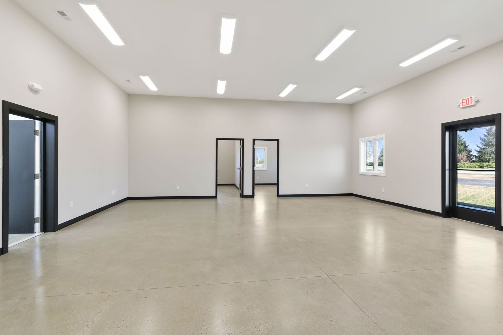 An empty room with white walls and a concrete floor