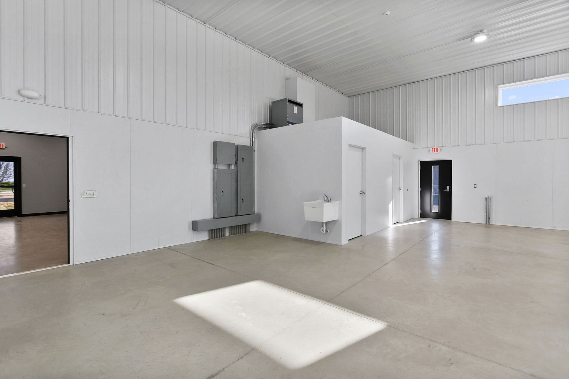 A large empty warehouse with white walls and a concrete floor.