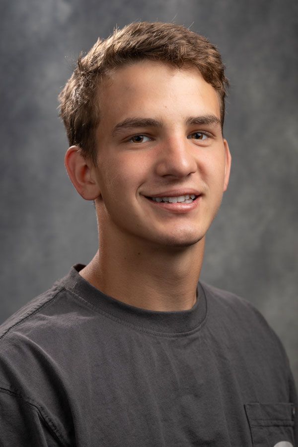 A young man with braces on his teeth is smiling for the camera.