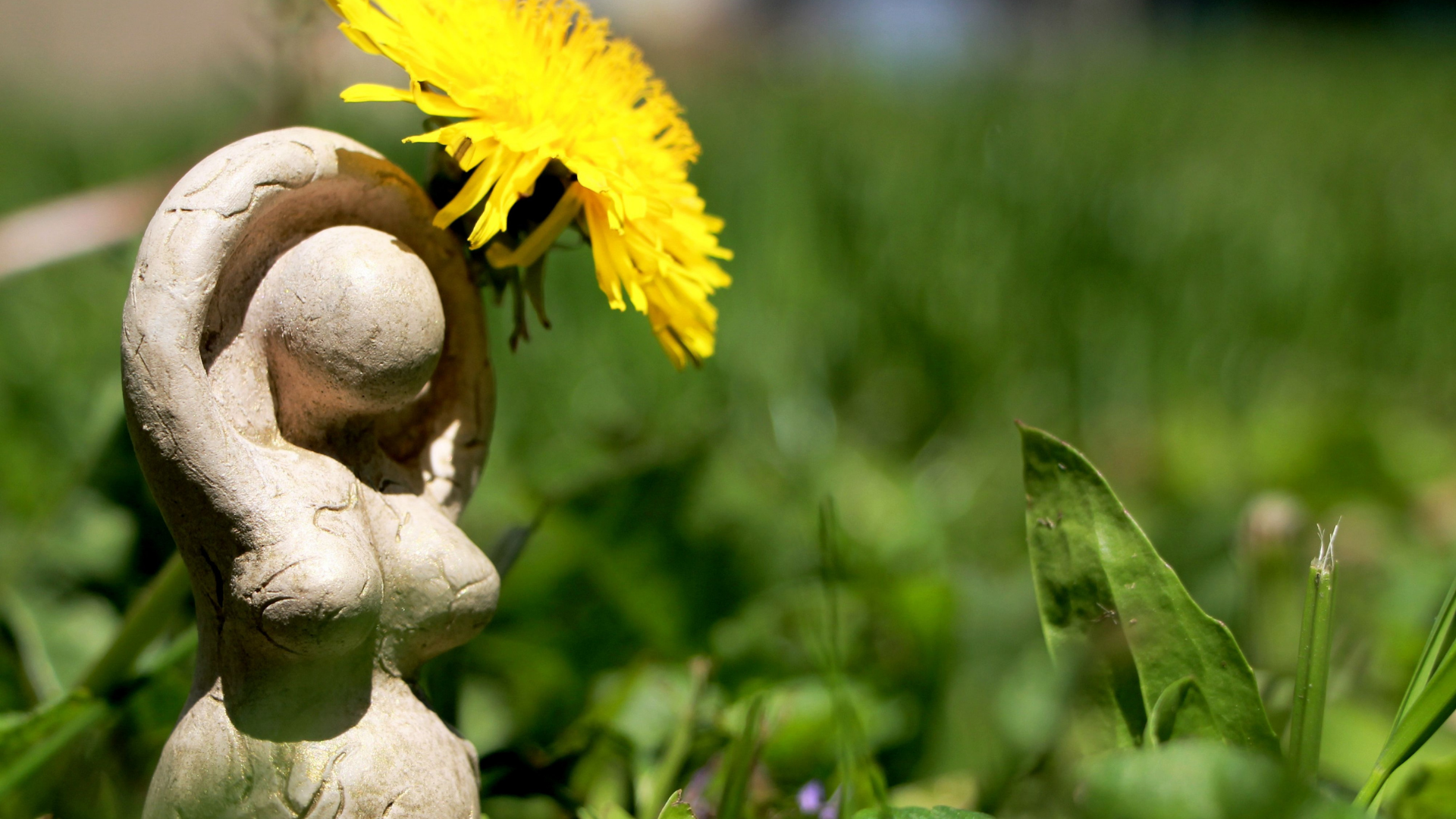 A statue of a woman holding a dandelion in her hand.