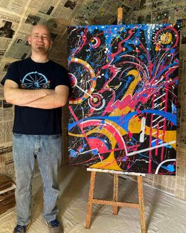 Ryan Conway, standing next to abstract painting in his studio