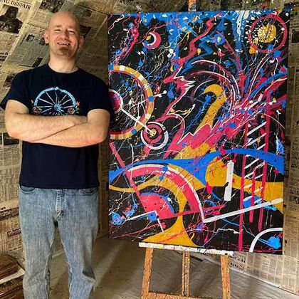 Ryan Conway standing in front of one of his paintings