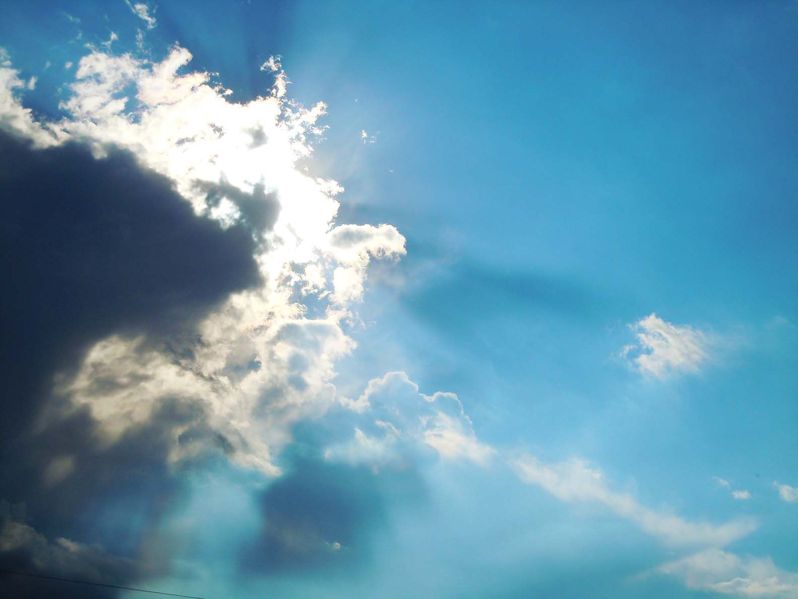 The sun hiding behind a cloud