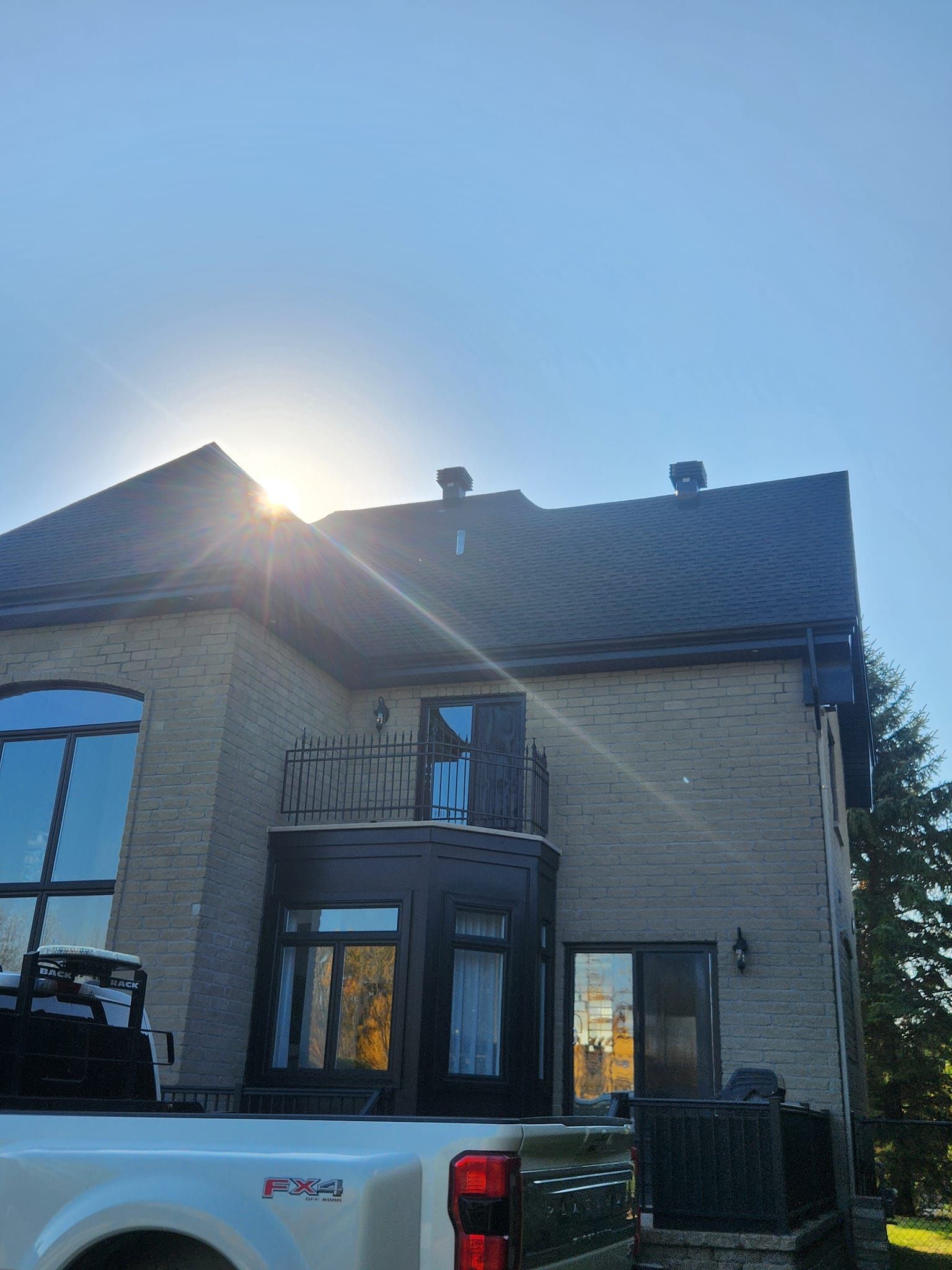 Maison en briques de deux étages avec balcon. Le soleil brille de mille feux.