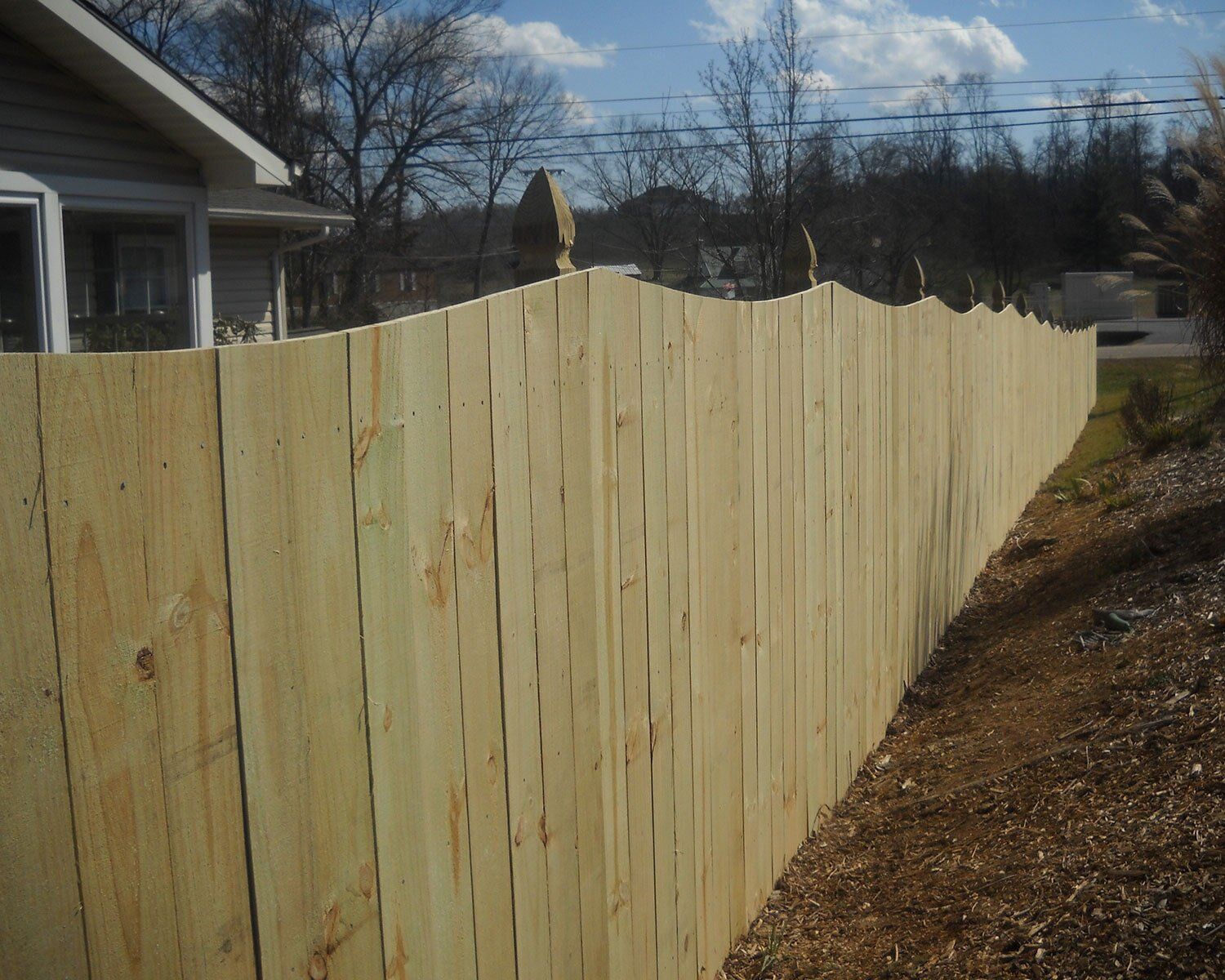 A wooden fence with a house in the background