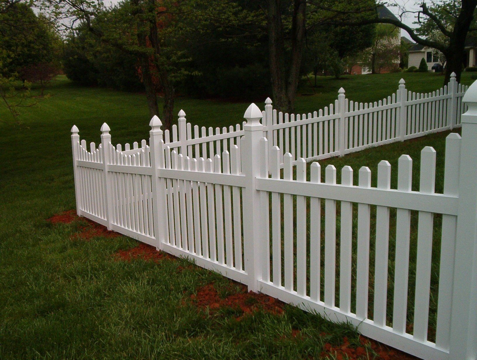 A white picket fence surrounds a lush green yard.