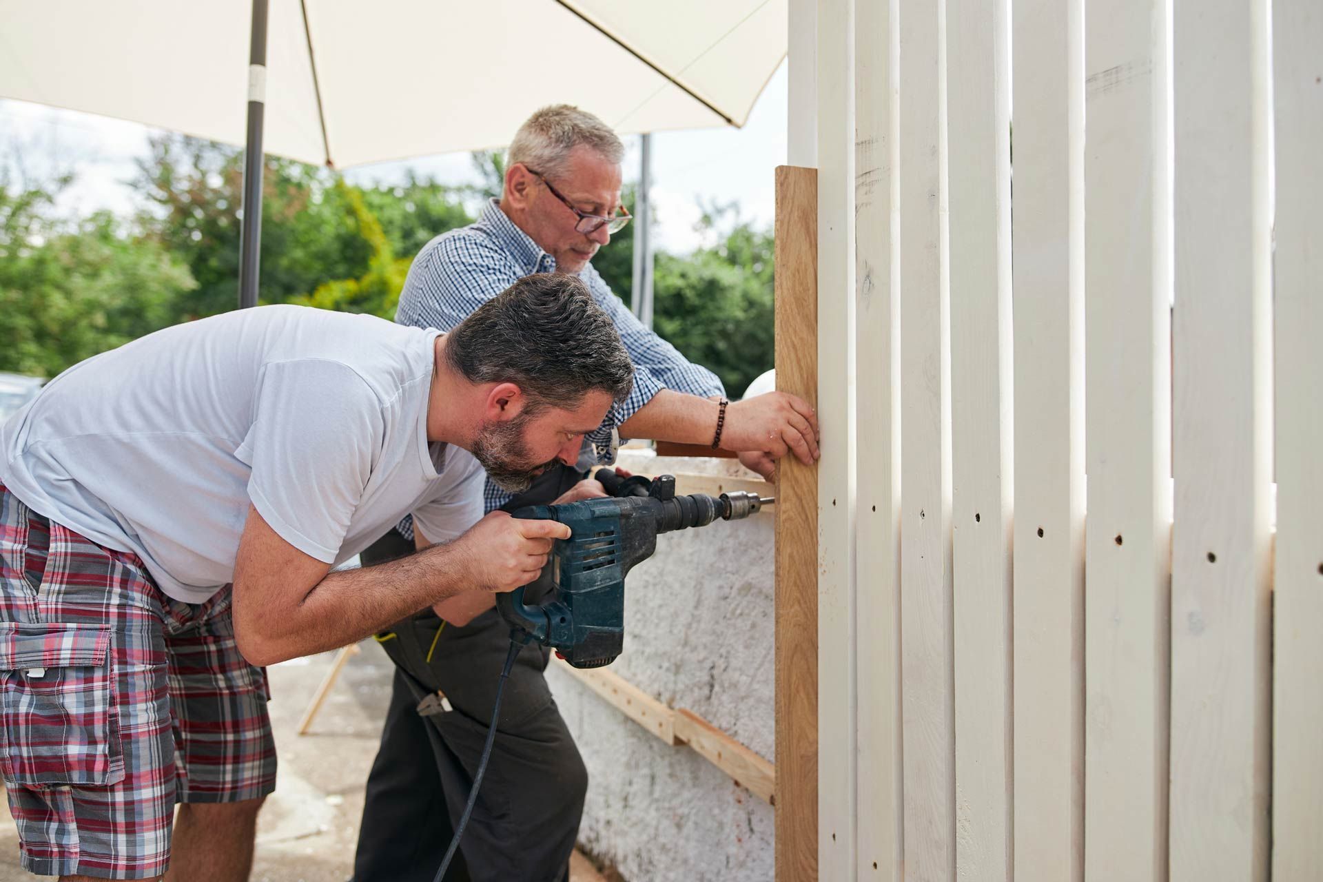 Two men are installing a fence.