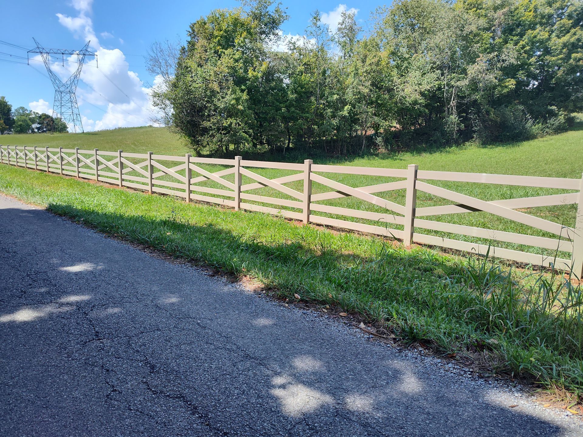 A wooden fence is along the side of a road.