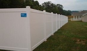 A long white fence in a grassy area