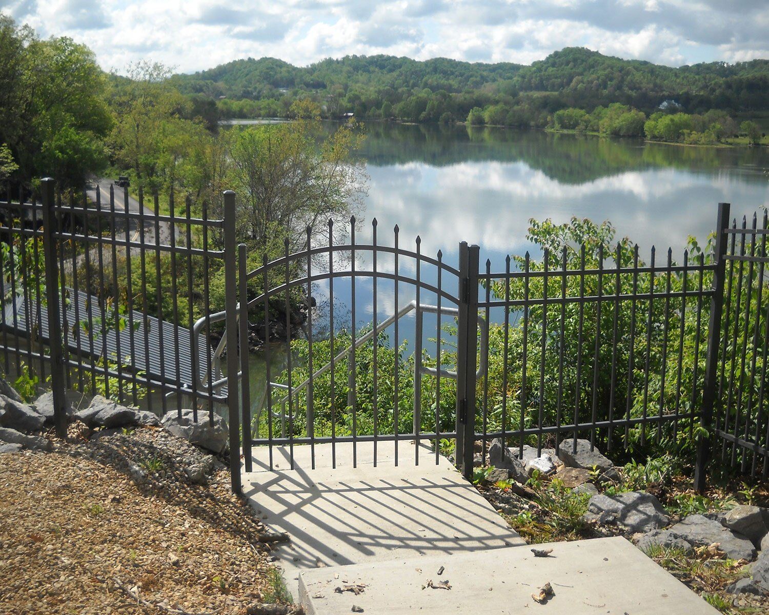 A gate leading to a lake with mountains in the background