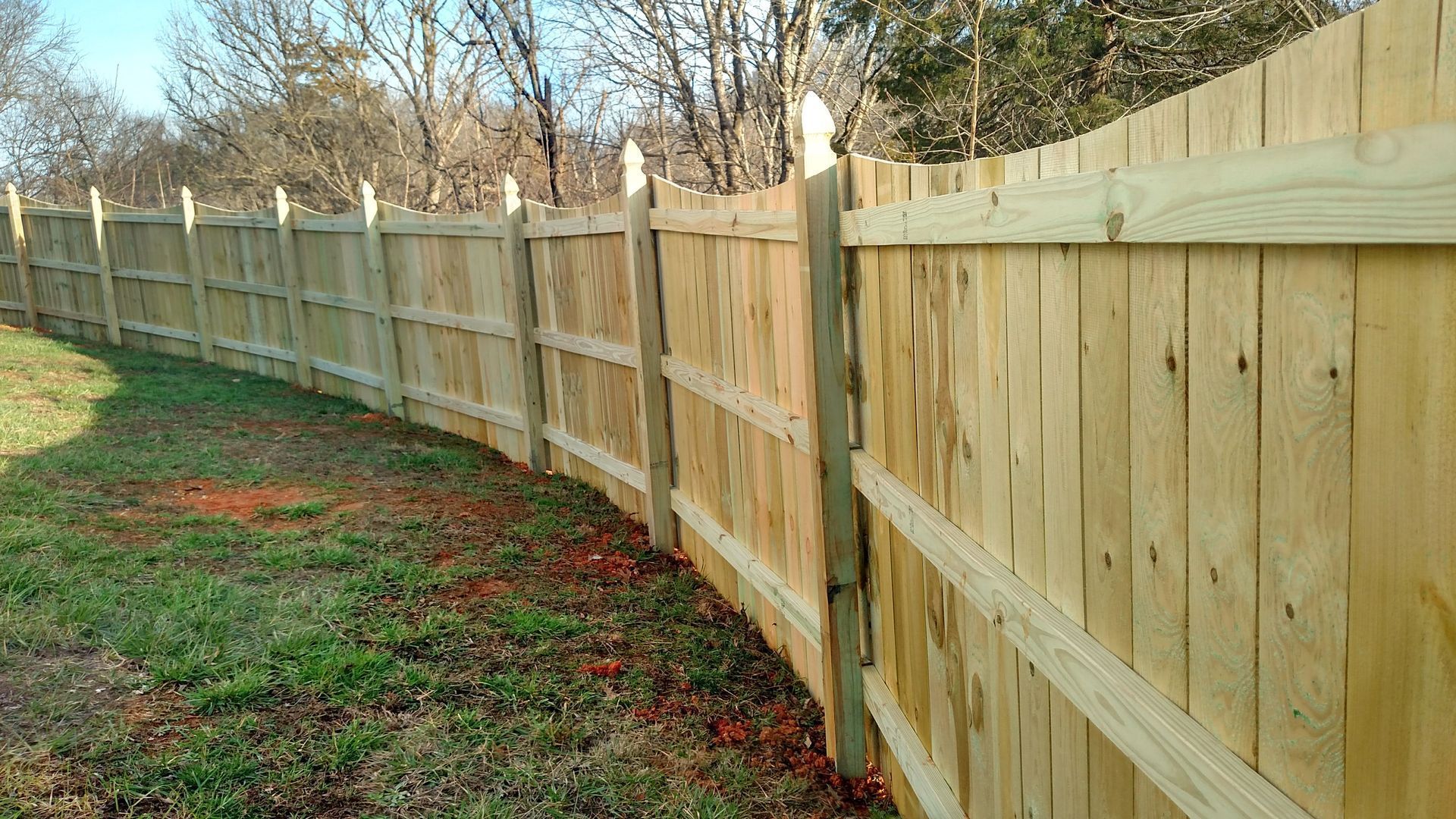 A wooden fence is sitting in the middle of a grassy field.