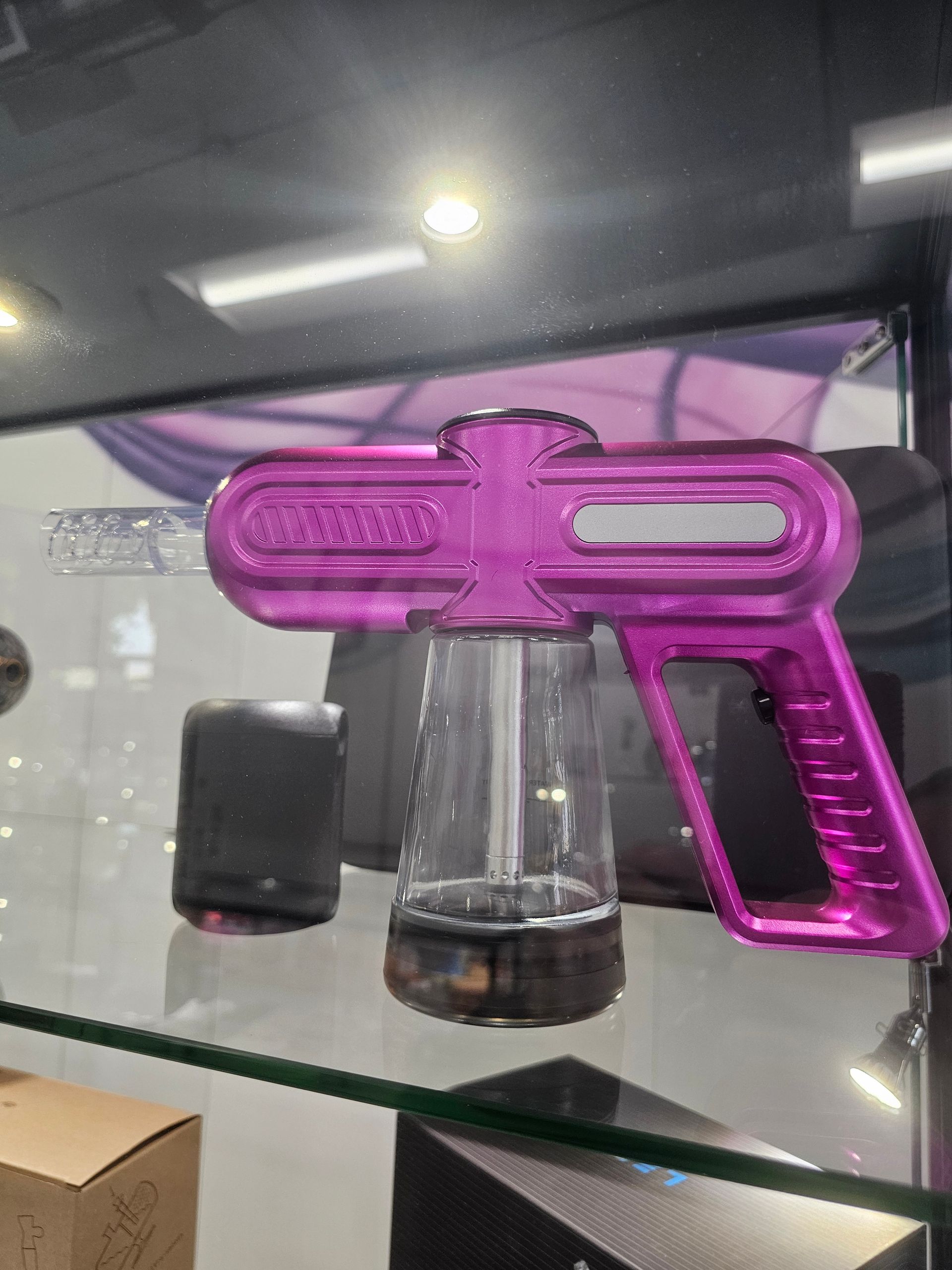 A variety of glass pipes are on display on a glass shelf.