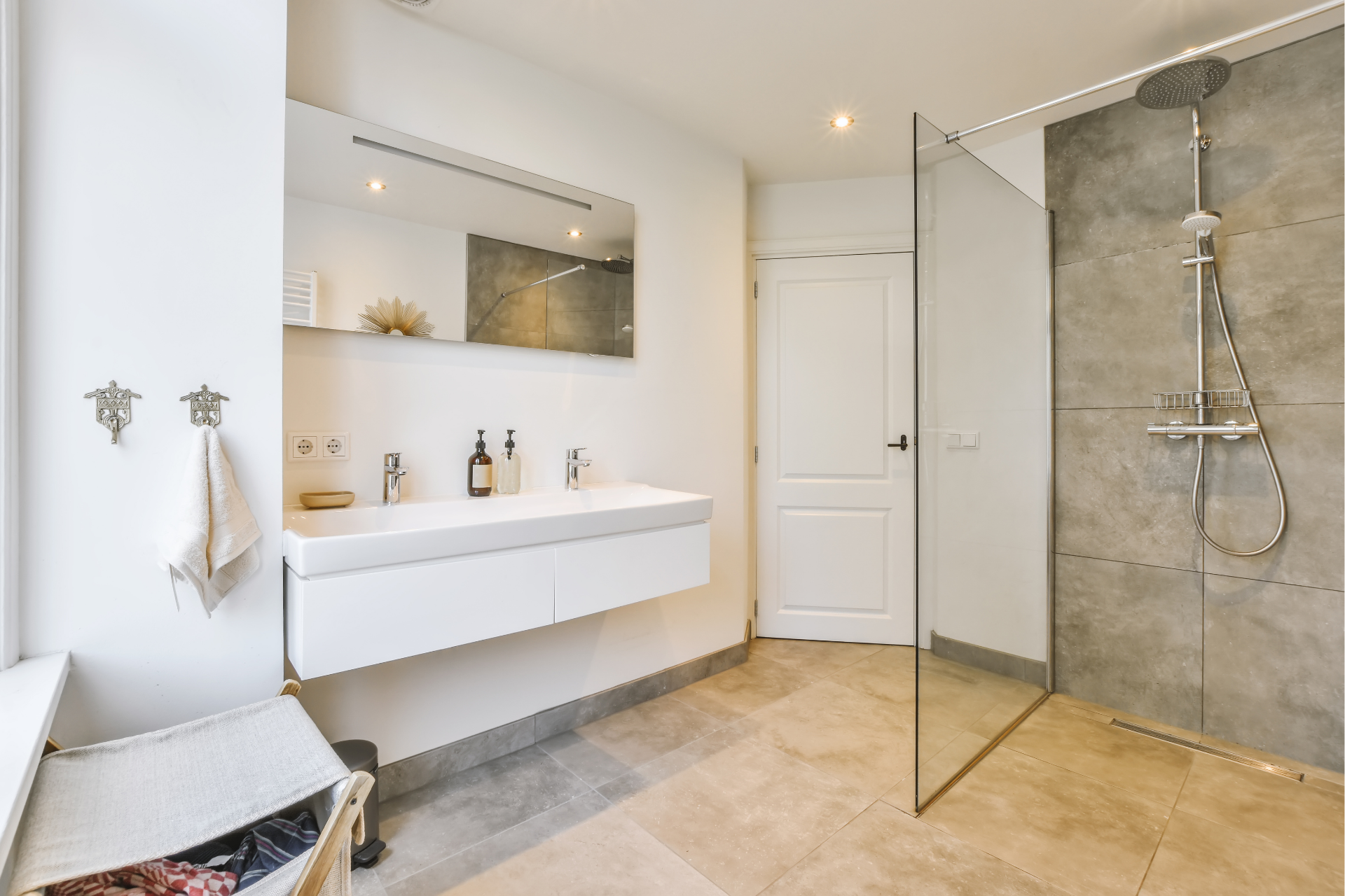 Une salle de bain avec douche à l'italienne, lavabo et miroir.