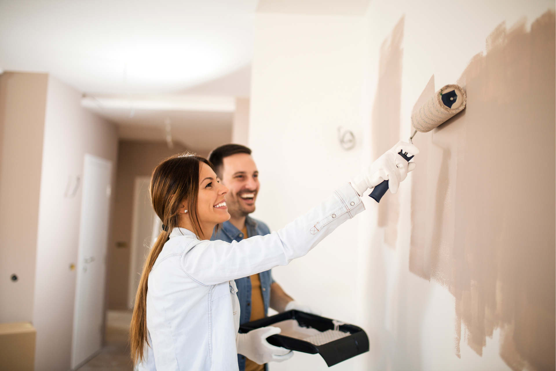 Un homme et une femme peignent un mur ensemble.