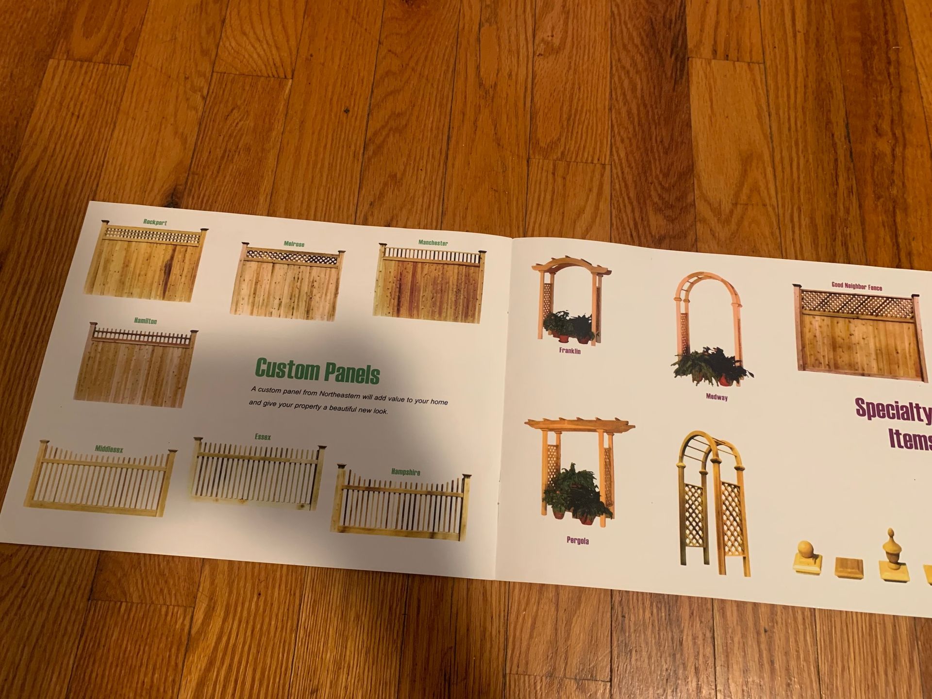 Brochure of garden fence panels and arches on a wood floor.