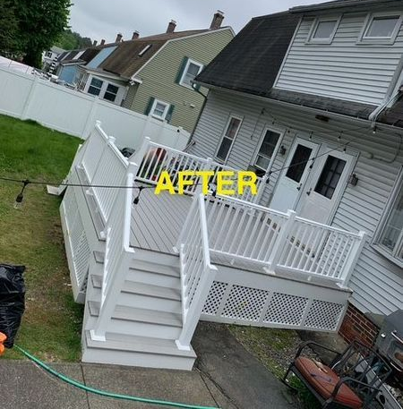Wooden fence in a backyard, surrounding a house with a deck.