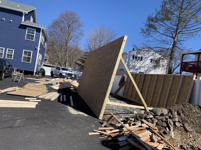 Construction of a wooden shed outdoors, with a partially built A-frame structure.