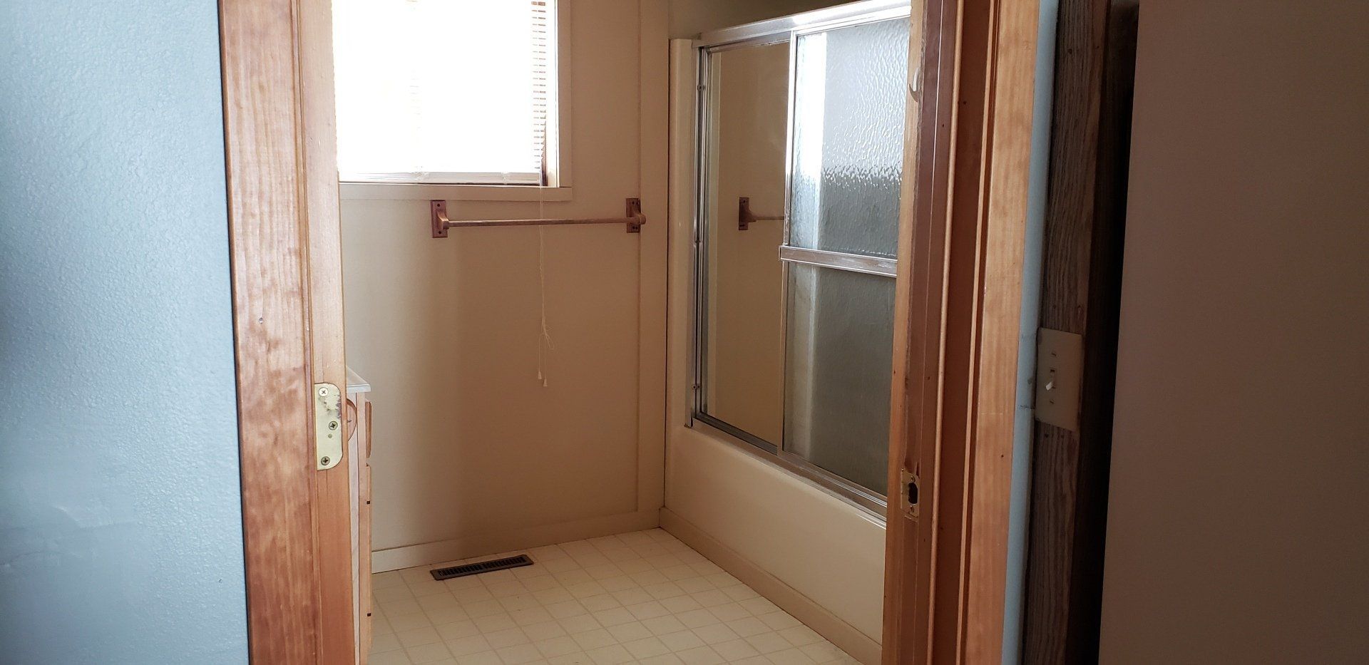 An empty bathroom with a bathtub and a window.