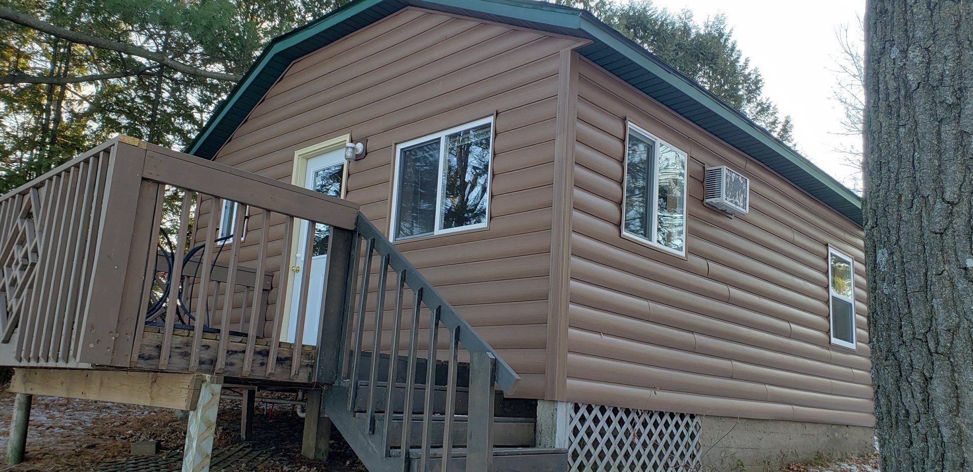 A small log cabin with stairs leading up to it.