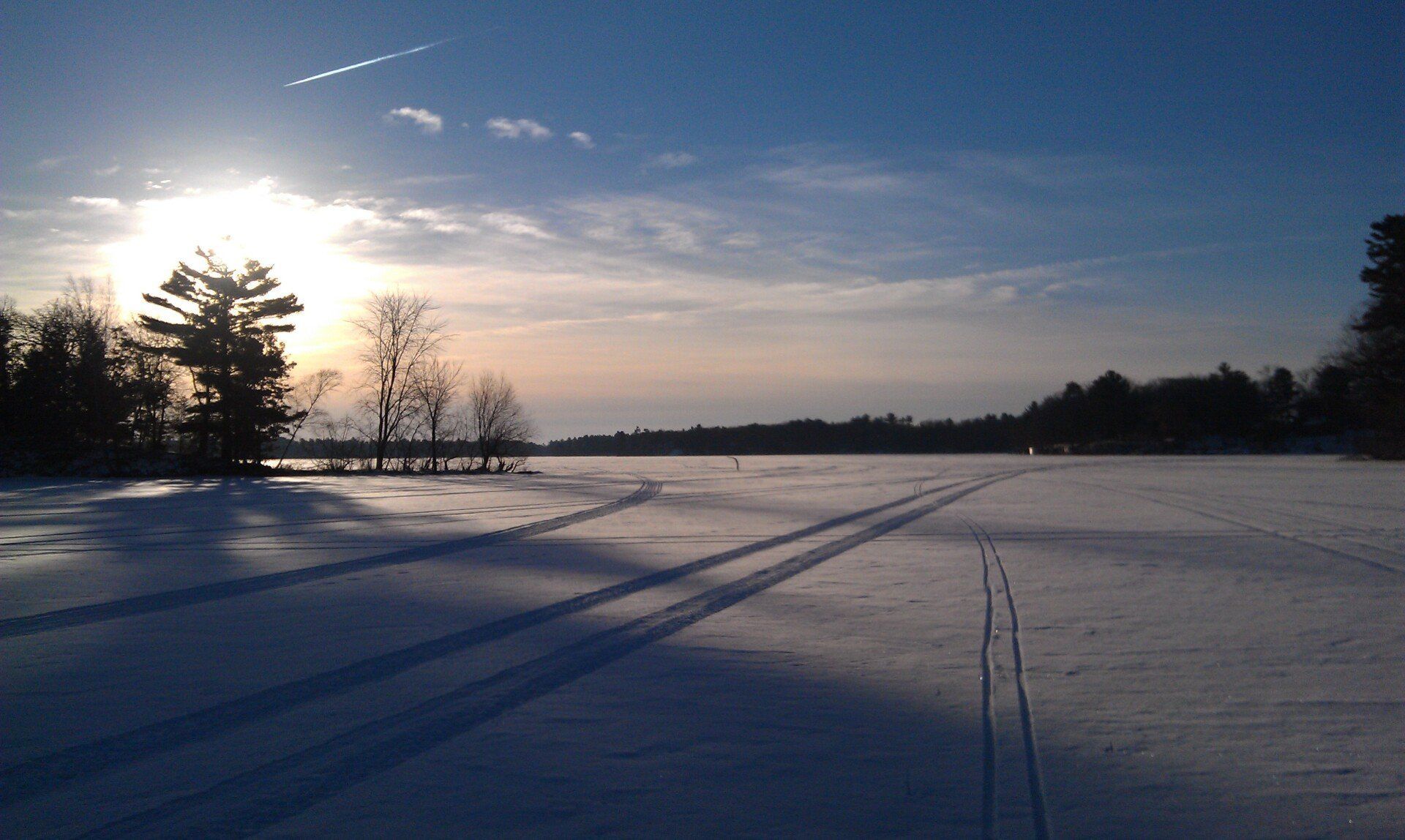 A snowy field with a sunset in the background
