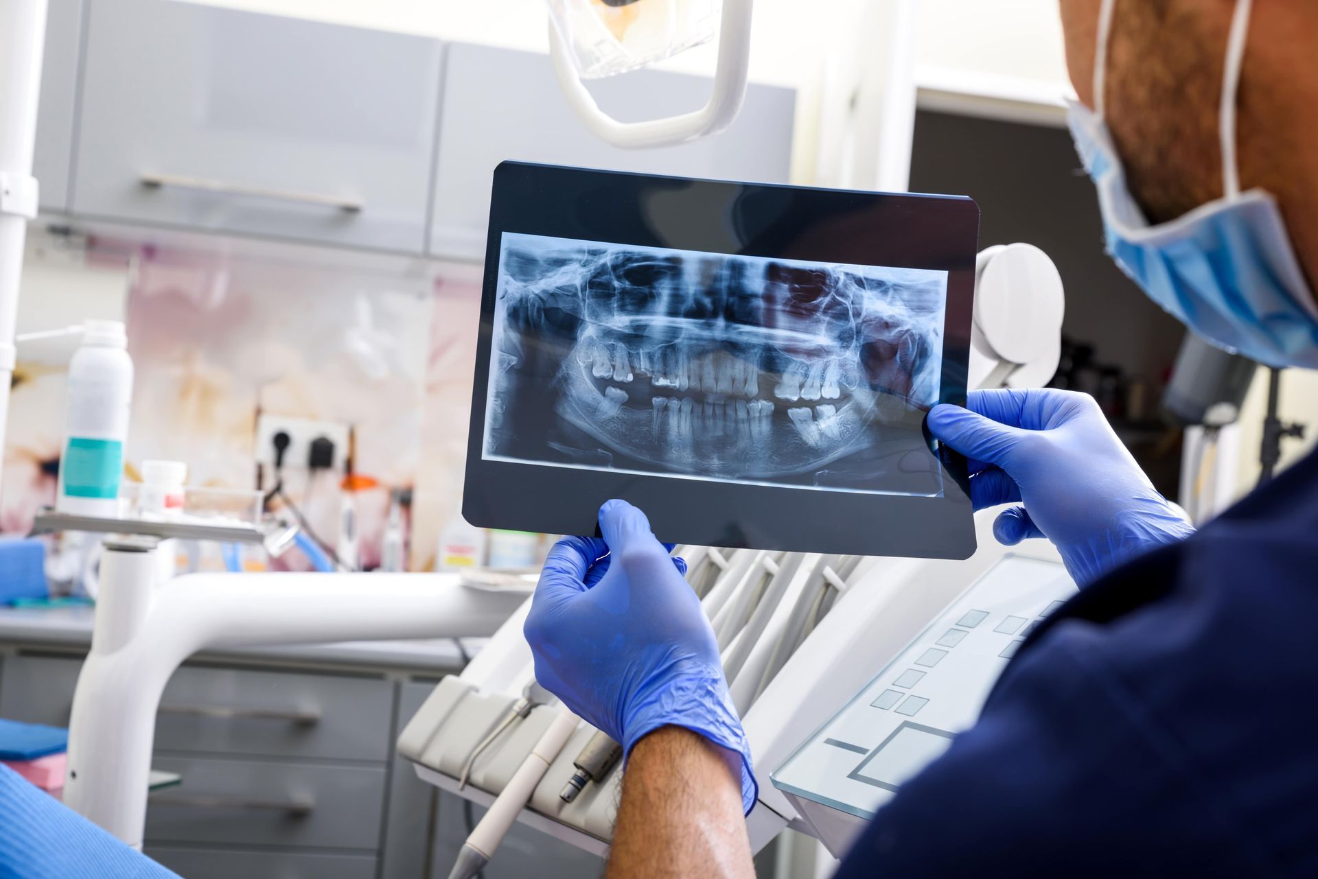 Two dental professionals treating a patient in an exam room.