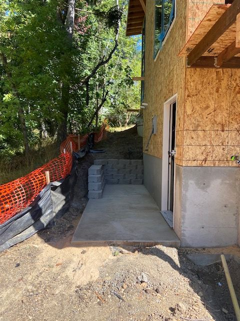 Empty room with hardwood floor, gray walls, and two large windows with a city view. A tall mirror stands in the middle.