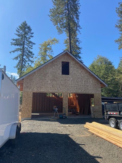 Empty garage with a speckled floor, gray door, and bright overhead lighting.