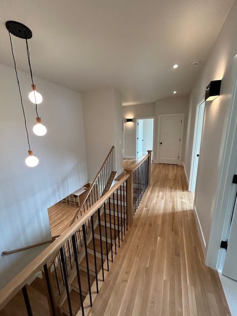 Electrician working inside an open electrical panel, using tools to check wiring.